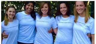 Five women surgeons in matching light-blue T-shirts
