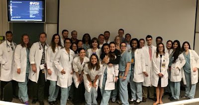 A large group of surgeons and trainees in white coats