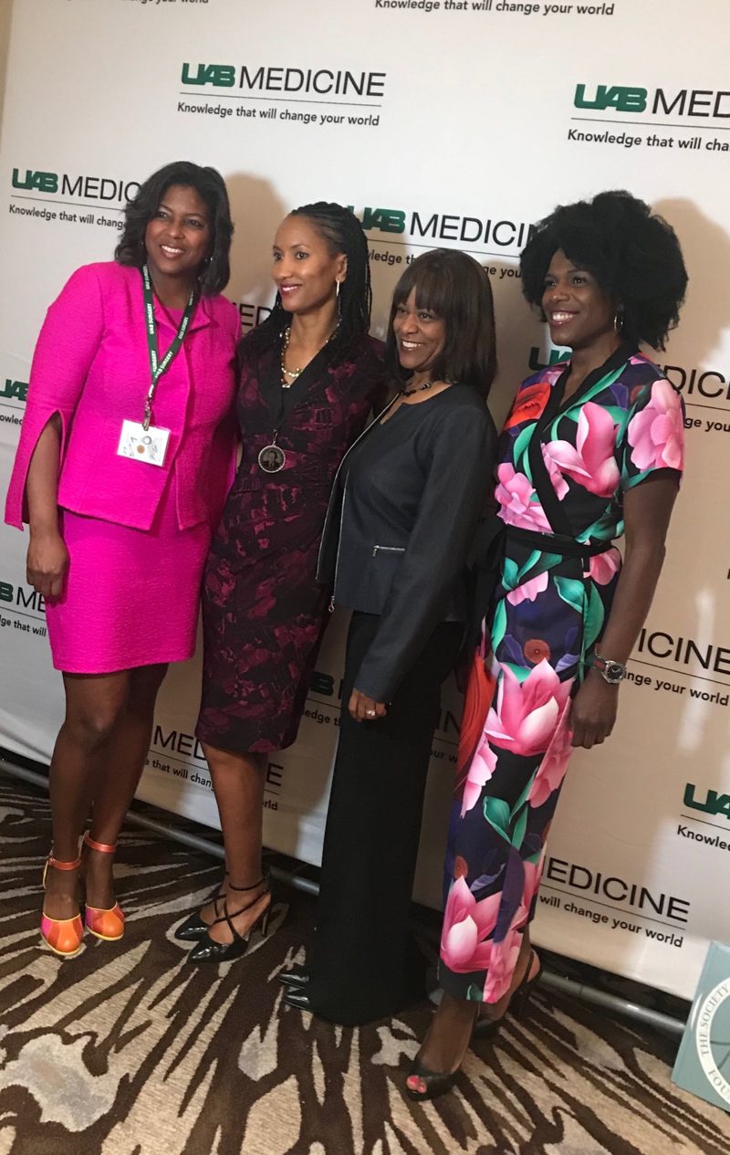 Four women surgeons in bright dresses at a UAB Medicine event
