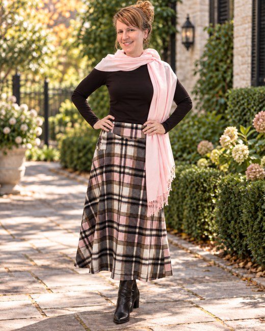 Heather in a pink scarf and plaid skirt on a garden path &mdash; an AI-assisted composite made from a mirror selfie